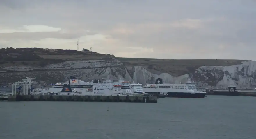 Kilka promów cumuje przy białych klifach. Jeden z nich, z napisem "DFDS", szykuje się do rejsu do Szkocji.