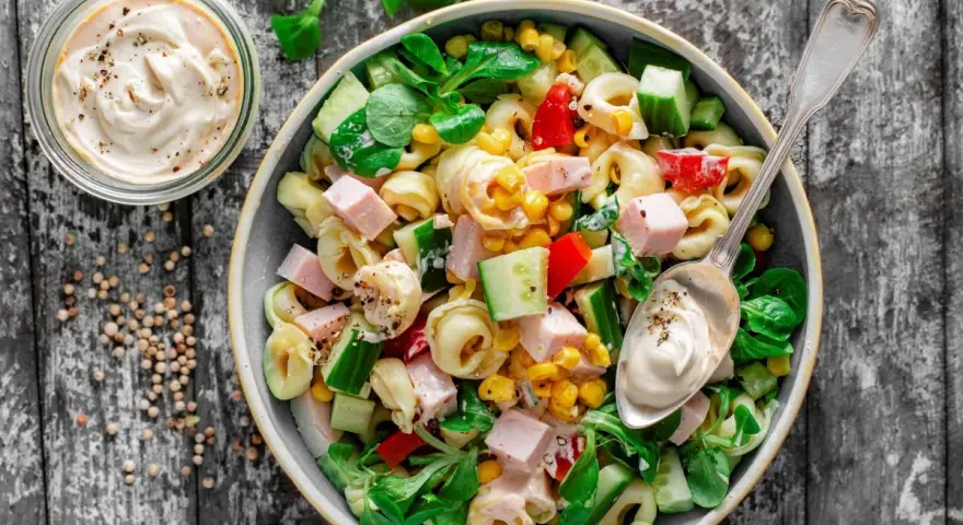 Najlepsza sałatka z tortellini: makaron, szynka, kukurydza, ogórek, papryka i zielona sałata, polana kremowym sosem.