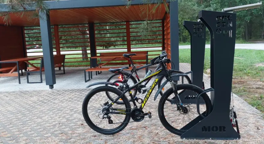 Miejsce obsługi rowerzystów z wiatą i stojakami. Dwa rowery czekają na dalszą podróż.