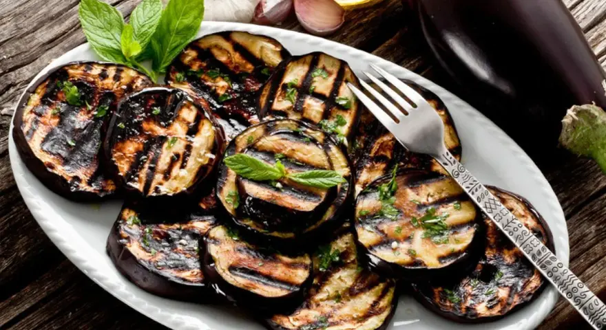Melanzane grigliate condite con erbe fresche e olio d'oliva. Un contorno saporito e facile da preparare.