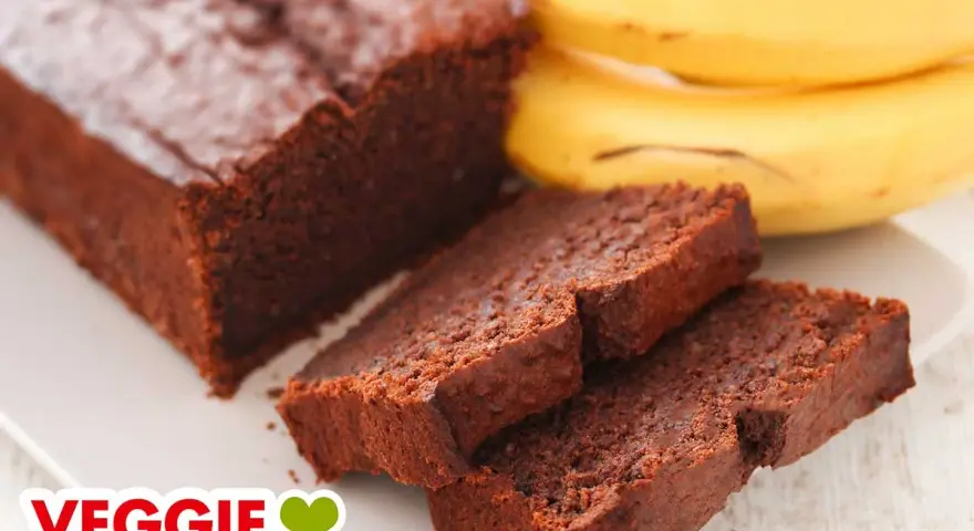 Saftiger schoko bananen kuchen vegan, daneben ein paar reife Bananen. Perfekt für Naschkatzen!