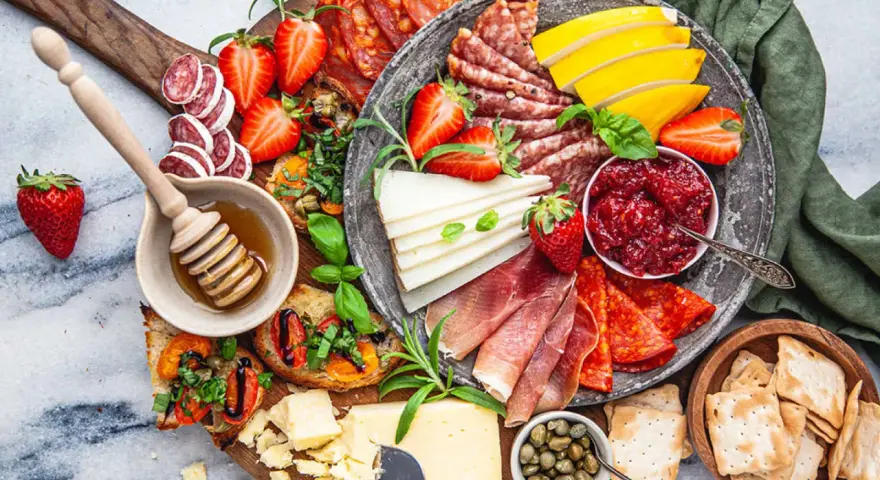 En härlig charkbricka med salami, prosciutto, ost, jordgubbar, marmelad och kex. Perfekt för mingel!