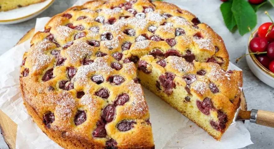 Saftiger Kirschkuchen, perfekt für das Kirschkuchen Rezept. Mit Puderzucker bestäubt und voller Kirschen.