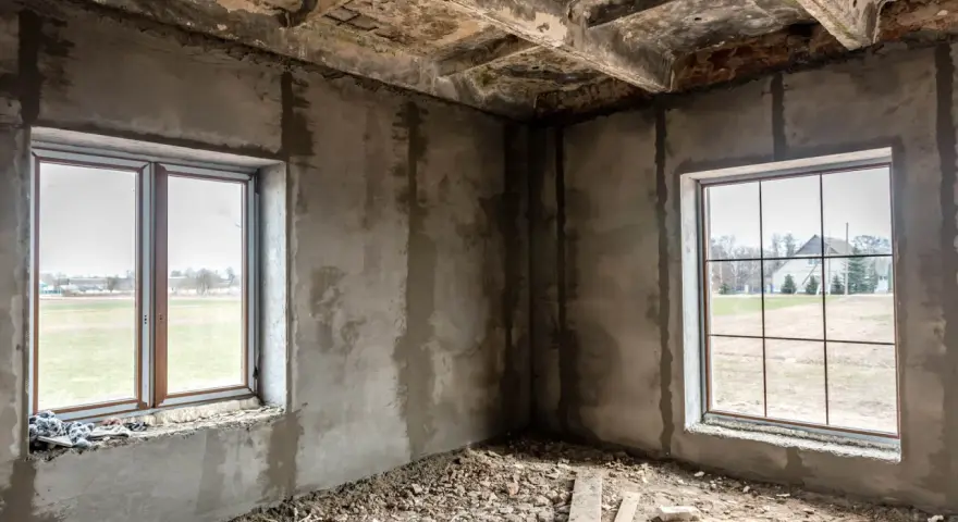 Wnętrze w budowie, dwa okna wychodzą na pola. Odległość okna od granicy działki i zgoda sąsiada to kluczowe kwestie przy planowaniu.