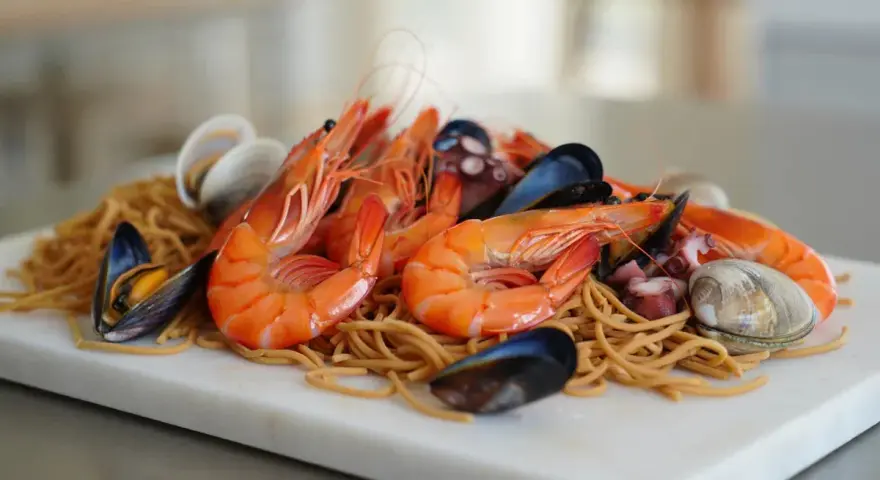 Fideuá de marisco con gambas, mejillones, almejas y pulpo sobre fideos finos.