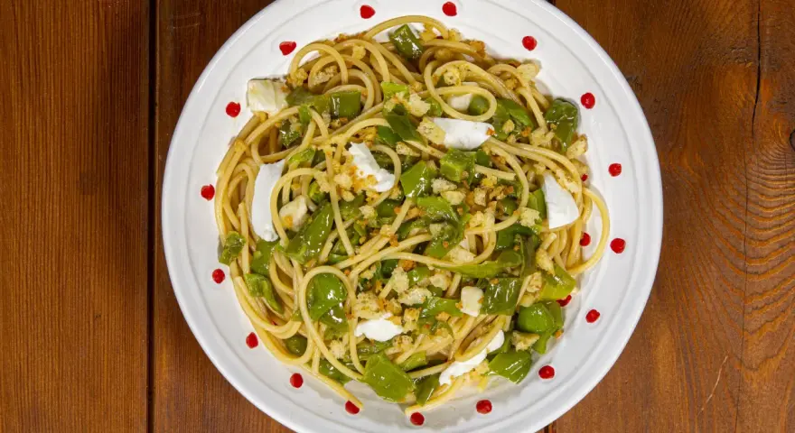 Spaghetti con friggitelli, mozzarella e pangrattato croccante. Un piatto semplice e gustoso, perfetto per un pranzo veloce.