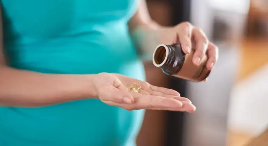 Donna incinta prende capsule, preoccupata per possibili augmentin effetti collaterali.