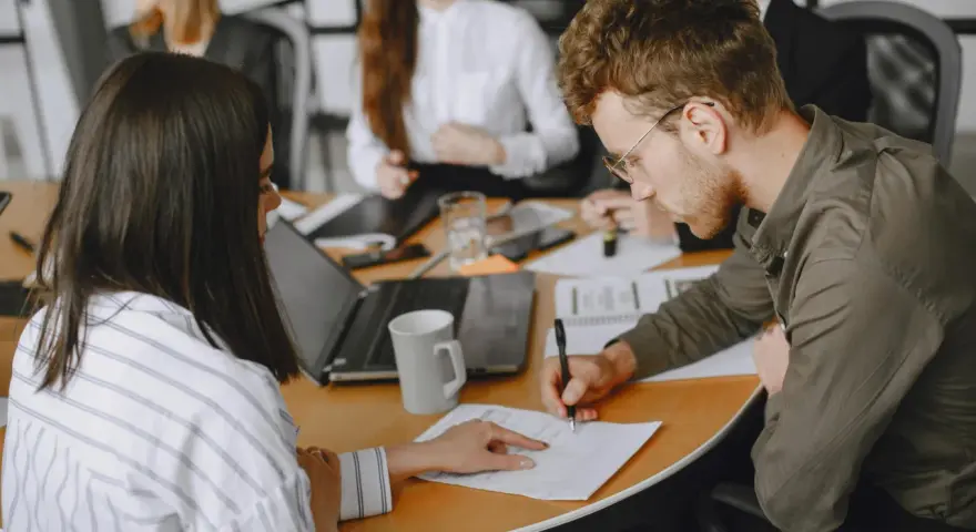 Uomini e donne in riunione, concentrati sul lavoro. Le 40 ore settimanali sono un impegno serio per raggiungere gli obiettivi.