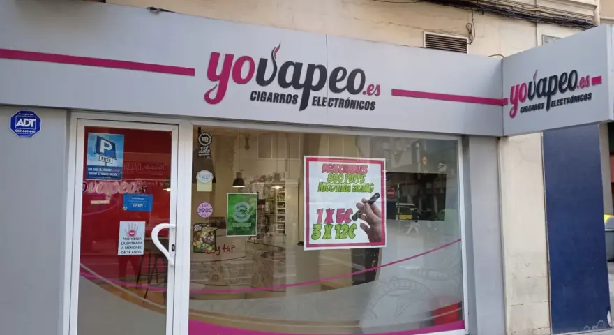 Tienda "yovapeo.es" de cigarros electrónicos. Un cartel anuncia "vaper quema garganta" con ofertas.