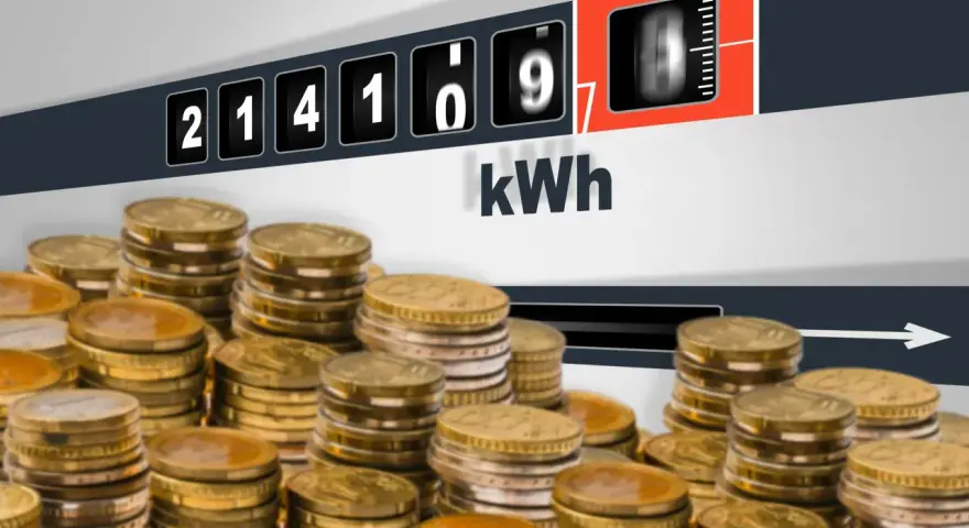 Liczniki energii pokazują zużycie kWh, a stosy monet sugerują pytanie: ile za kWh Tauron?
