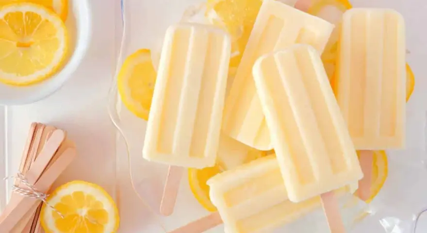 Erfrischendes Zitronen Wassereis selber machen ist einfach! Hier sind cremige Eis am Stiel mit frischen Zitronenscheiben.