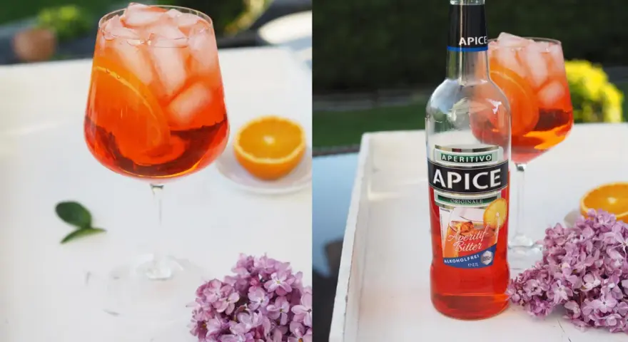 Erfrischender alkoholfreier Aperol mit Eis und Orangenscheiben, daneben eine Flasche Apice Aperitif Bitter.