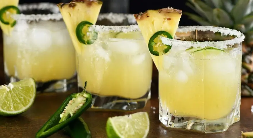 Orzeźwiający drink z coroną, ananasem i jalapeño, z solą na brzegu szklanki. Idealny na upalne dni.