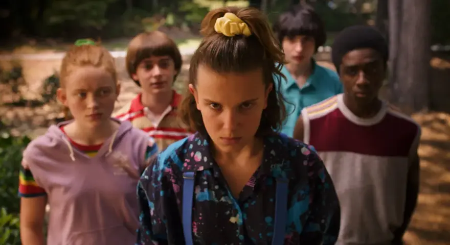 Die Gruppe aus Stranger Things, bereit für ein Abenteuer, während die ikonische Stranger Things Musik im Hintergrund spielt.