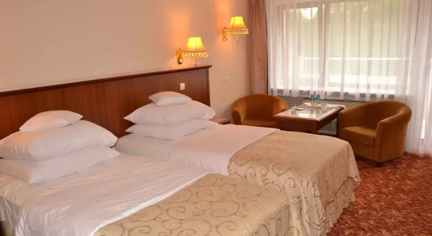 Przytulne hotel Gołębiewski pokoje z dwoma wygodnymi łóżkami, stolikiem i dwoma fotelami.