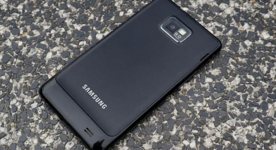 Czarny Samsung Galaxy S2 leży na kamienistej nawierzchni.
