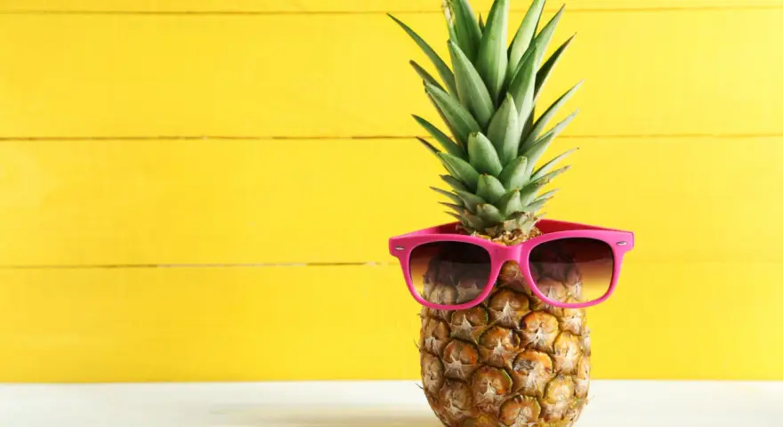 Ananas w okularach przeciwsłonecznych na żółtym tle. Czy wiesz, jaki ananas indeks glikemiczny ma dla diabetyków?