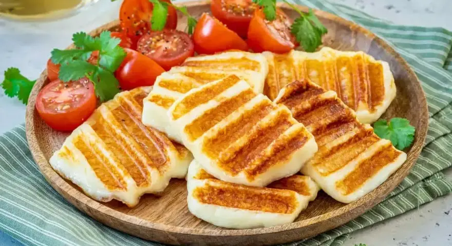 Grillowany ser halloumi z pomidorkami koktajlowymi i kolendrą. Idealny pomysł, co zrobić z sera halloumi na lekki posiłek.
