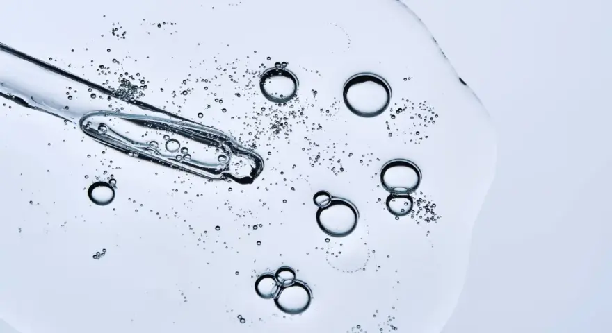 Kropla serum z pipetką, pełna pęcherzyków powietrza. Czy peptydy można łączyć z witaminą C? To pytanie nurtuje wiele osób dbających o cerę.