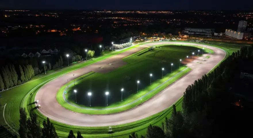 Vue aérienne d'un hippodrome illuminé la nuit, rappelant le nombre d'hippodrome en France.