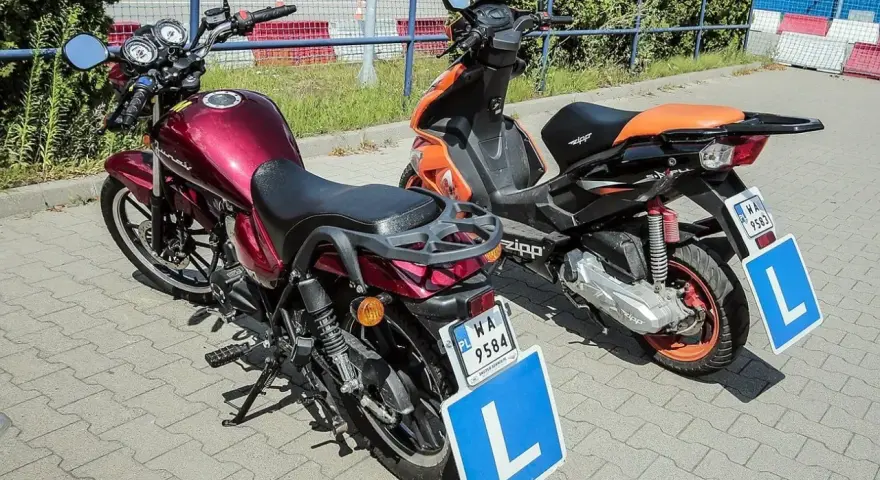 Dwa pojazdy, motocykl i skuter, z tabliczkami "L" na błotnikach, gotowe do nauki jazdy. Karta motorowerowa wkrótce będzie ich przepustką.
