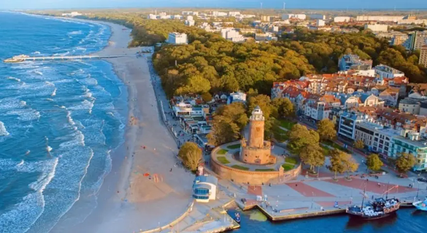 Idealne miejsce, gdzie nad morze. Widok na plażę, molo, latarnię i nadmorskie miasteczko.