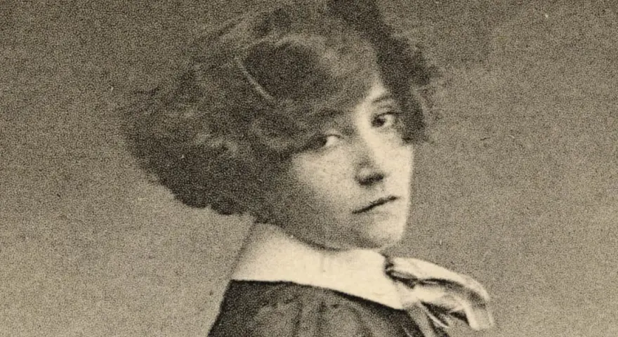 Portrait de Colette jeune, regardant par-dessus son épaule, avec une coiffure bouclée et un col blanc.