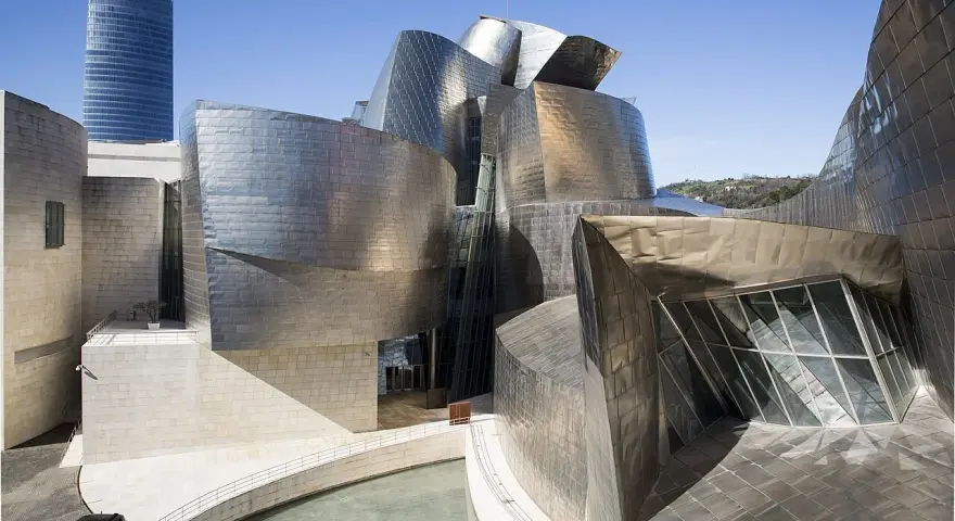 Spektakularny efekt Bilbao: falujące, metaliczne formy Muzeum Guggenheima w Bilbao, odbijające niebo i otoczenie.