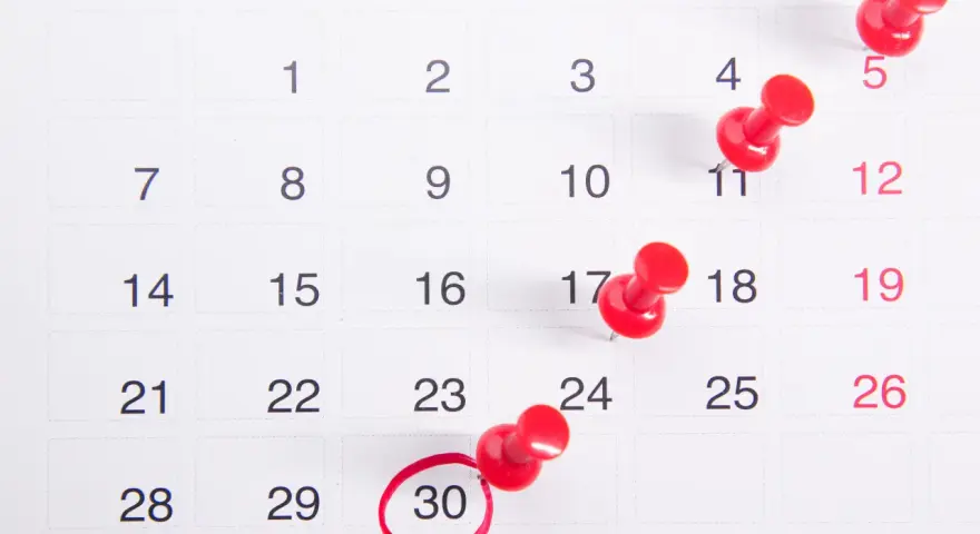 Calendario con chinchetas rojas marcando días. El día 30 está rodeado, recordando que en hostelería se pagan los festivos.