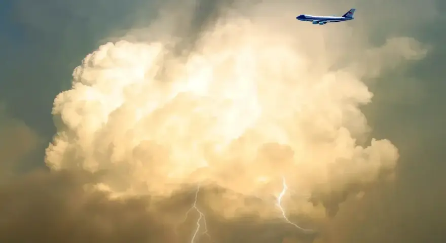 Samolot leci obok burzowej chmury z błyskawicami. To pokazuje, co to są turbulencje.