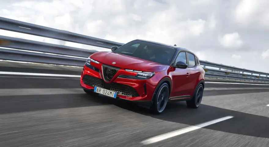 Czerwony Alfa Romeo Junior elektryczny SUV na drodze.