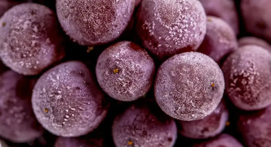 Gefrorene rote Weintrauben mit Eiskristallen, bereit zum Einfrieren für erfrischende Snacks.