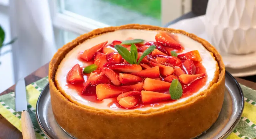 Cheesecake con mascarpone e fragole fresche, guarnita con menta. Un dolce invitante, perfetto per ogni occasione.