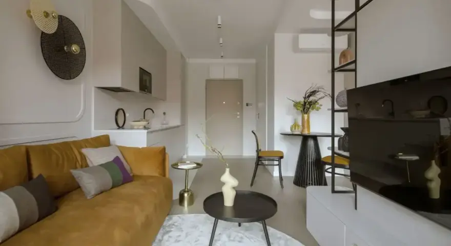 Nowoczesny salon z kanapą w kolorze musztardowym, tworzącą ciepłą paletę kolorów ziemi.