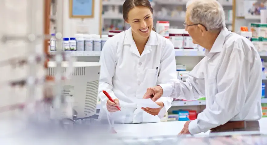 Farmaceutka pomaga seniorowi zrealizować receptę na darmowe leki.