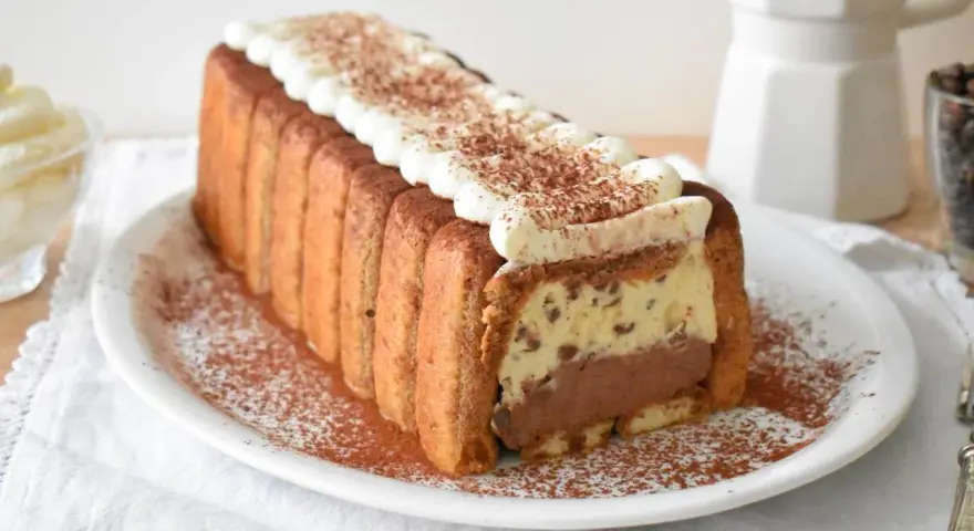 Pyszne włoskie ciasta: tiramisu w kształcie keksówki, otoczone biszkoptami, z kremem i kakao. Idealne na deser.