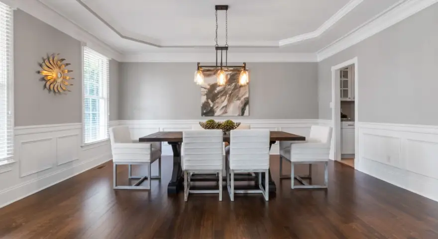 Comedor elegante con paredes y techo pintados del mismo color gris claro, creando un ambiente sereno.
