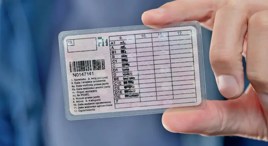 Prawo jazdy z zaznaczoną kategorią CE. Dokument w ręku, widoczne dane kierowcy i kategorie uprawnień.