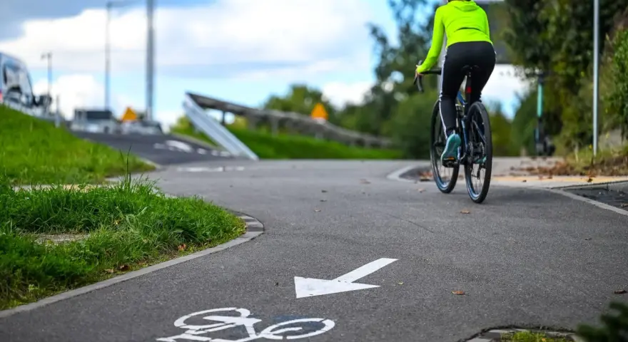 Kobieta na rowerze przemierza malownicze trasy rowerowe Kujawsko-Pomorskie.