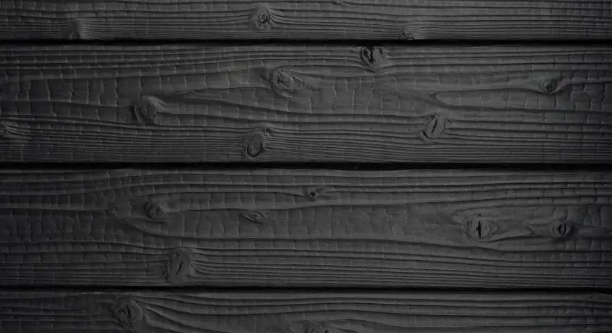 Tavolato scuro, con venature evidenti e nodi che emergono dal **legno bruciato**.