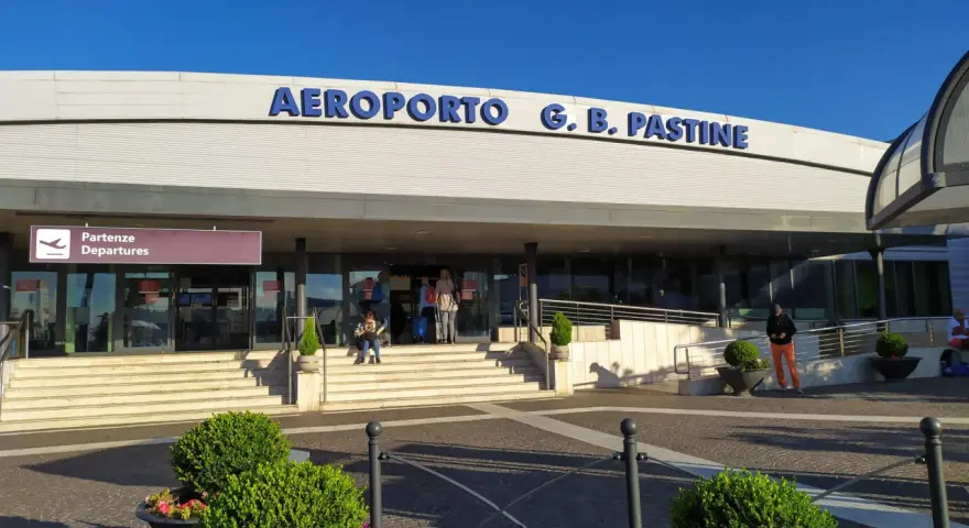 Wejście do Aeroportu G.B. Pastine w Rzymie Ciampino. Słoneczny dzień, ludzie czekają na odloty.