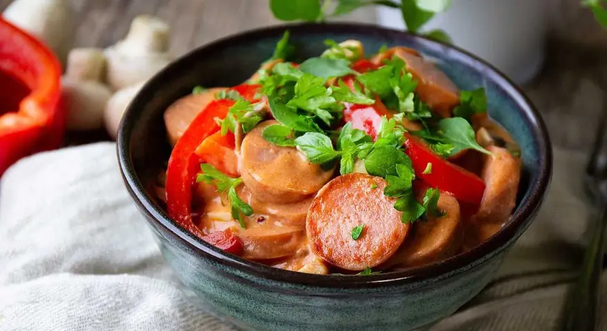 En mustig korvgryta med chorizo, paprika och örter i en krämig sås. Serveras i en rustik skål.