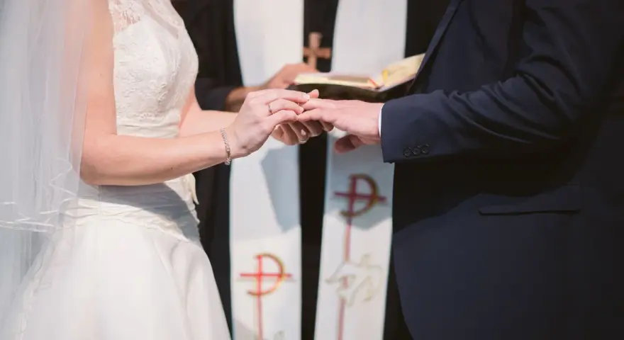 Para młoda wymienia obrączki podczas ceremonii ślubnej w kościele.