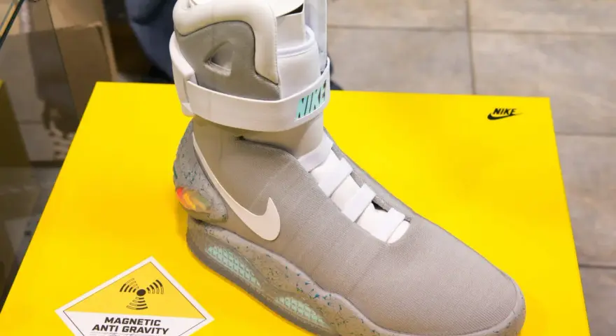 Nike Mag, najdroższe buty na świecie, z technologią "Magnetic Anti Gravity", prezentowane na żółtym tle.