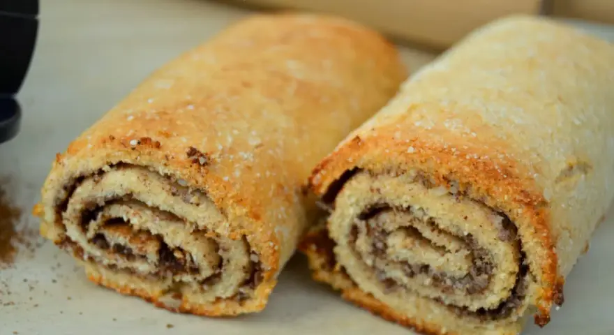 Två gyllene, nyttiga kanelbullar med synlig kanelfyllning. Perfekt för en hälsosam fika.