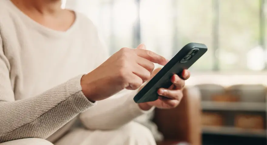 Dłoń z telefonem, przygotowująca się do wykonania czynności, jak przenieść dane z telefonu na telefon.