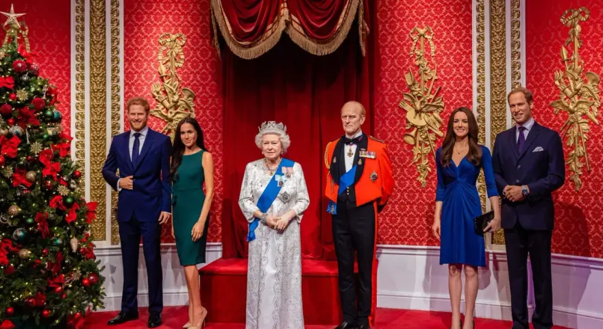 Figury królewskie w muzeum figur woskowych Londyn: Elżbieta II, książę Filip, książę Harry, Meghan Markle, książę William i Kate Middleton.