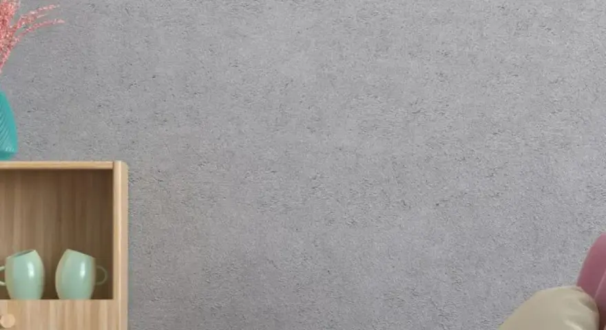 Un elegante papel pintado sobre gotele cubre la pared gris. Muebles de madera y tazas verdes decoran el espacio.