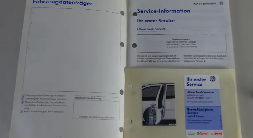 Ein offenes Serviceheft mit dem Titel "Fahrzeugdatenträger" und "Service-Information". Darunter Informationen zum Ölwechsel-Service und Bremsflüssigkeits-Service.