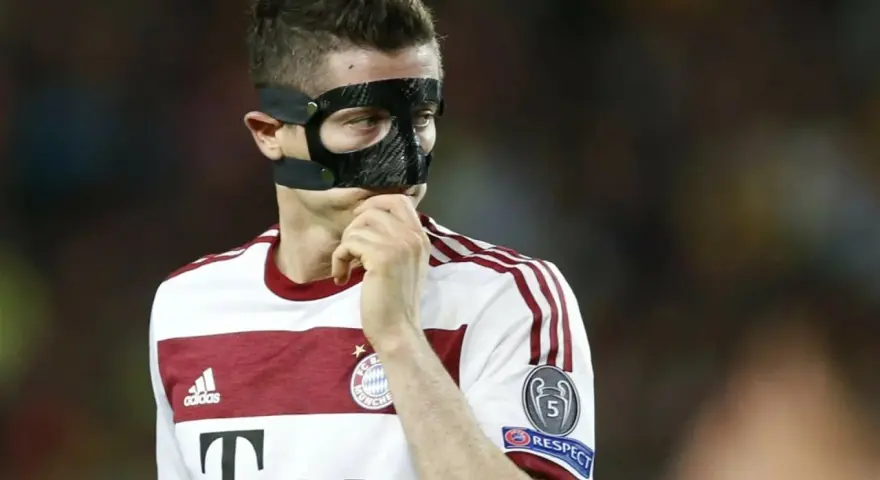 Piłkarz w masce ochronnej na twarzy, być może zastanawia się, dlaczego Lewandowski gra w masce.